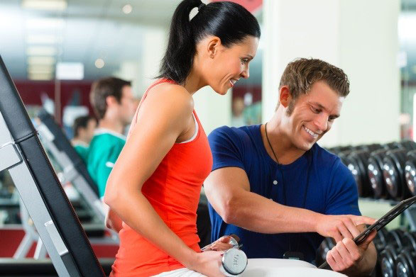 personal trainer helping a client on treadmill